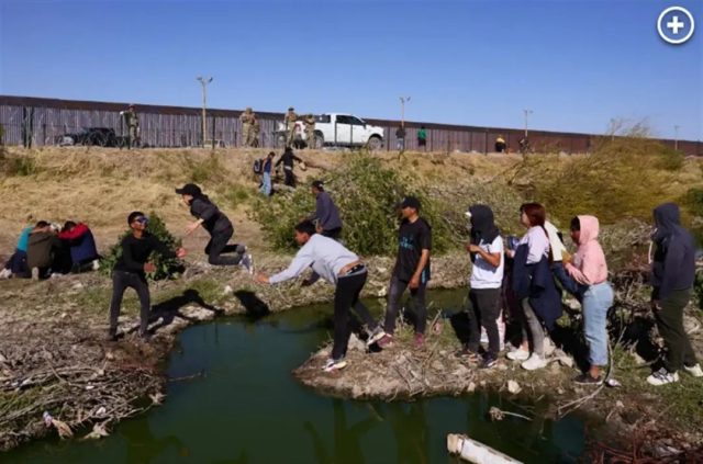 “让孩子先去”数千移民听谣言涌入边境,抱起孩子就扔过河。