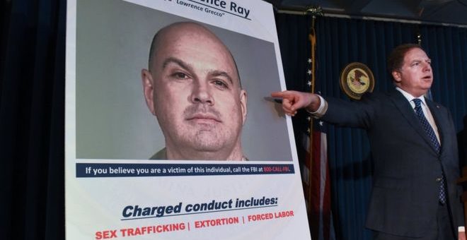 Manhattan US Attorney Geoffrey Berman points at a photo of Lawrence Ray as charges are announced in New York City in February 2020.